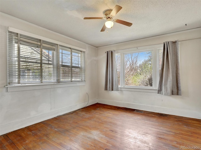 empty room featuring wood-type flooring, ceiling fan, and a textured ceiling