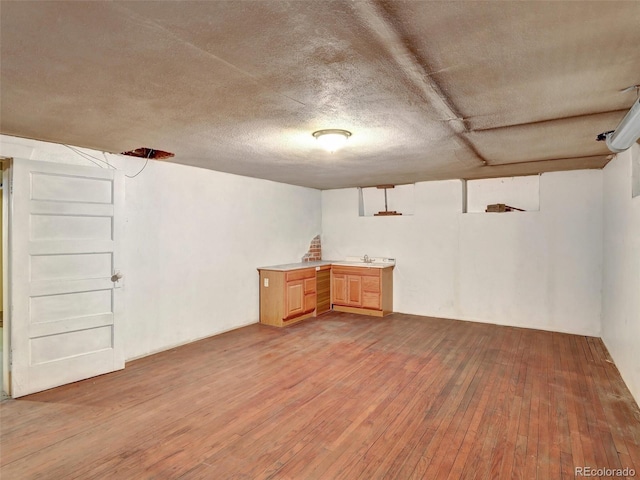 basement featuring sink and light wood-type flooring