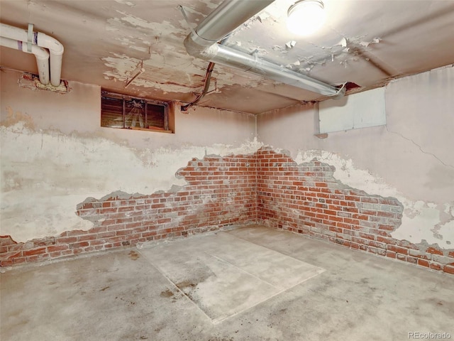 basement featuring brick wall