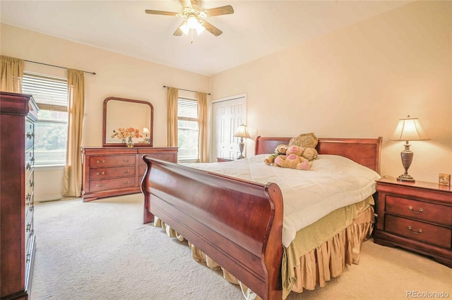 bedroom featuring ceiling fan, light carpet, and a closet