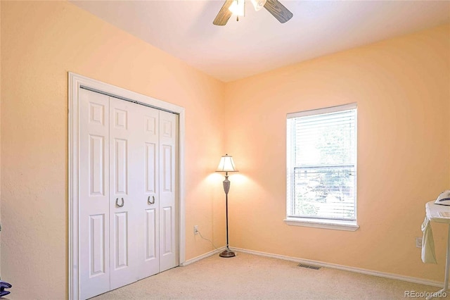 unfurnished bedroom with ceiling fan, a closet, and carpet