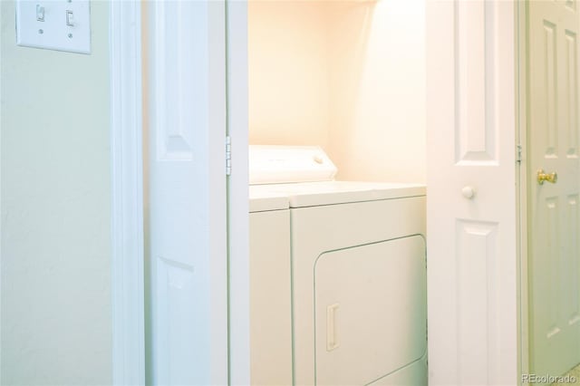 clothes washing area with washing machine and dryer