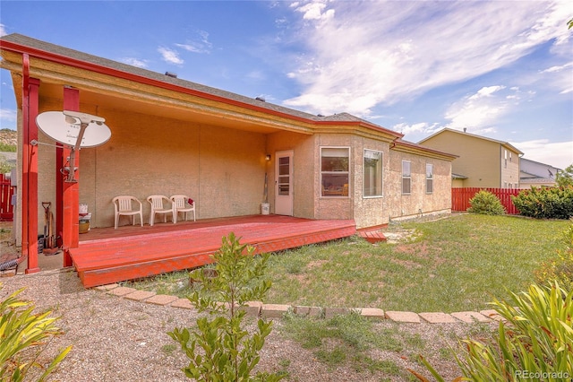 back of property featuring a lawn and a wooden deck