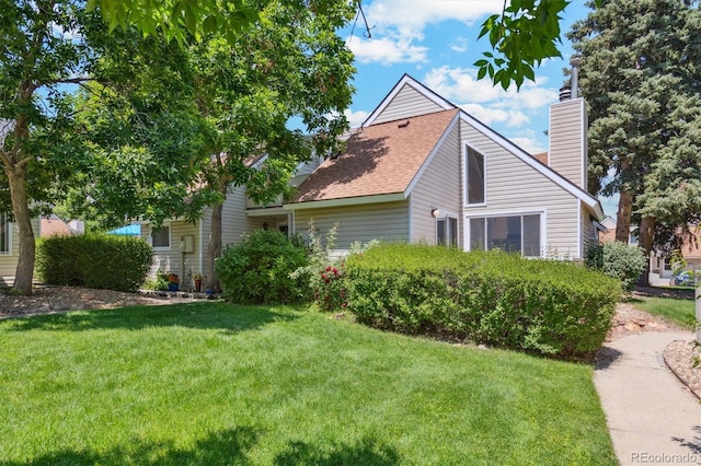 2453 S Xanadu Way Unit C, Aurora, CO 80014 - view of home's exterior with a yard, a chimney, and a shingled roof