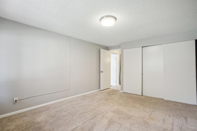 2453 S Xanadu Way Unit C, Aurora, CO 80014 - unfurnished bedroom with light colored carpet, a closet, and a textured ceiling