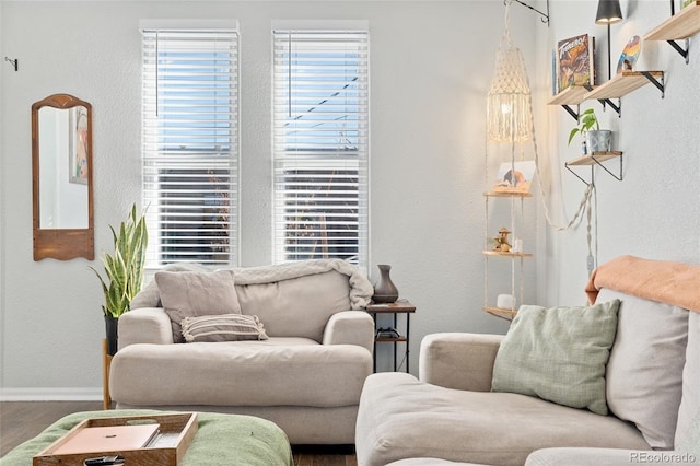 living room featuring a textured wall, baseboards, and wood finished floors