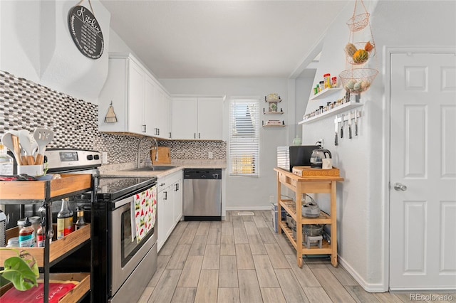 kitchen with a sink, white cabinets, light countertops, appliances with stainless steel finishes, and wood tiled floor