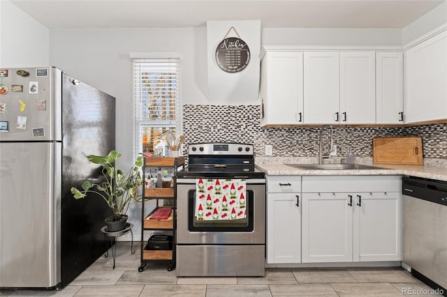 kitchen featuring white cabinetry, appliances with stainless steel finishes, light countertops, and a sink