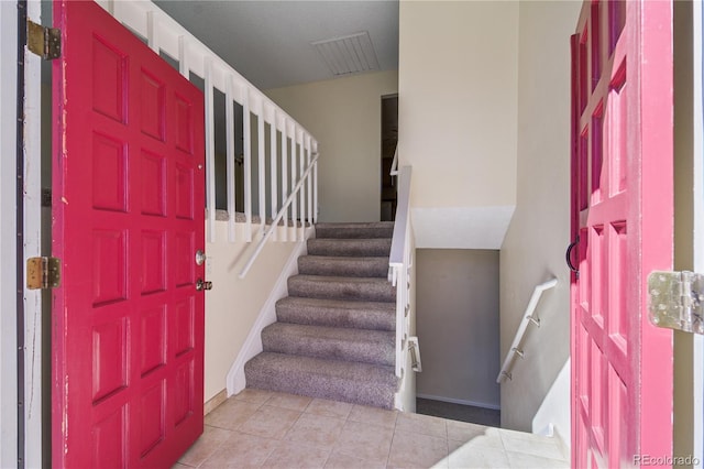 foyer entrance featuring visible vents, stairway, baseboards, and light tile patterned floors