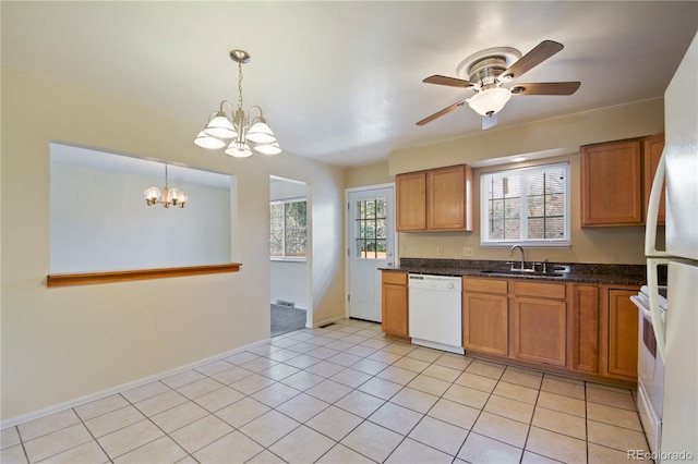 kitchen featuring light tile patterned floors, stove, brown cabinetry, a sink, and dishwasher