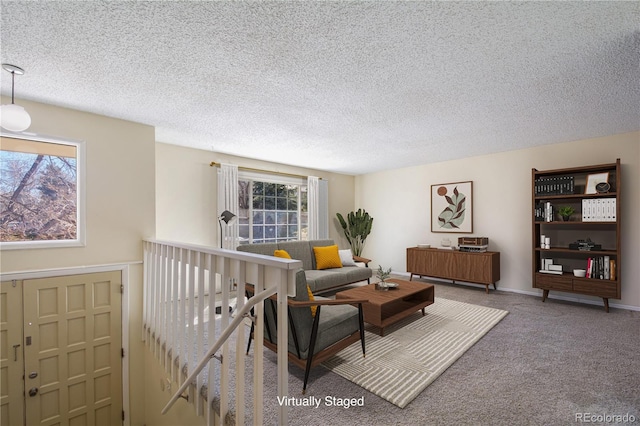 living area featuring a textured ceiling, carpet floors, and a healthy amount of sunlight