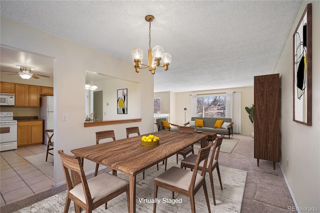 dining area featuring baseboards, light colored carpet, a textured ceiling, and light tile patterned flooring