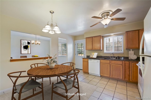 kitchen featuring white appliances, light tile patterned floors, brown cabinets, and a sink