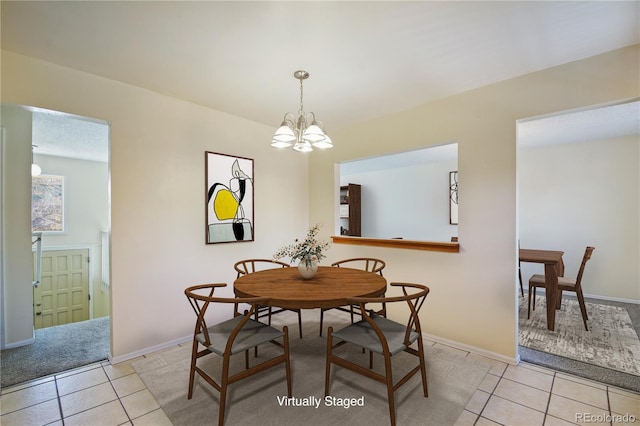 dining room featuring a notable chandelier, baseboards, and light tile patterned floors