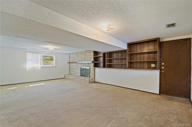 unfurnished living room featuring light colored carpet, visible vents, a fireplace, and a textured ceiling