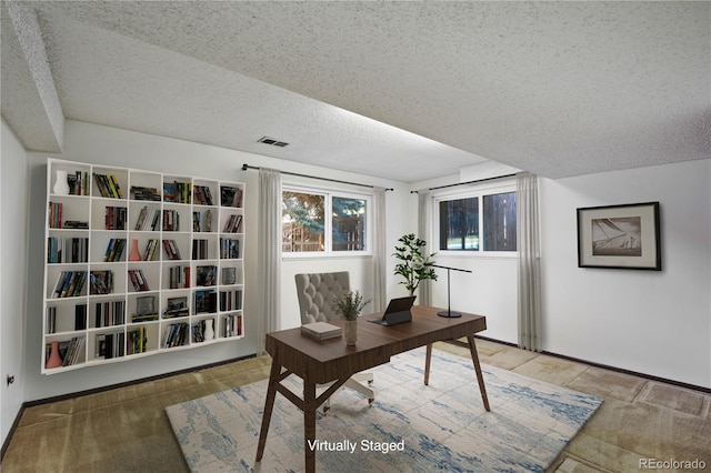 office space with visible vents and a textured ceiling