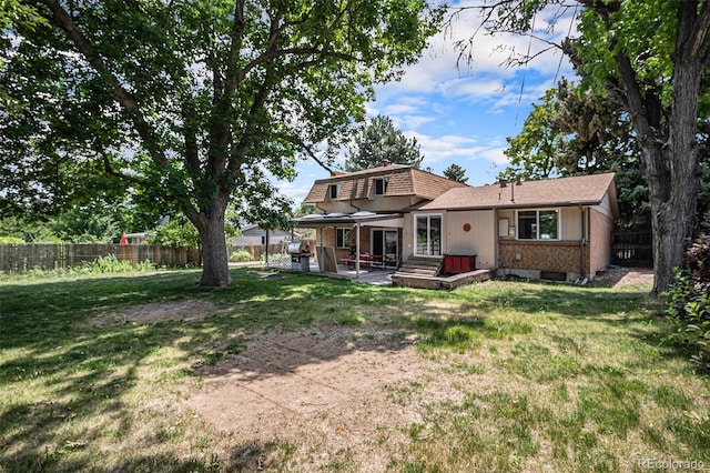8727 E Girard Ave, Denver, CO 80231 - back of house featuring a fenced backyard, brick siding, and a patio area