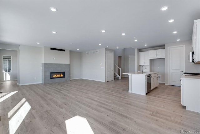13398 E 99th Pl, Commerce City, CO 80022 - kitchen featuring dishwasher, a sink, baseboards, white cabinets, and light countertops