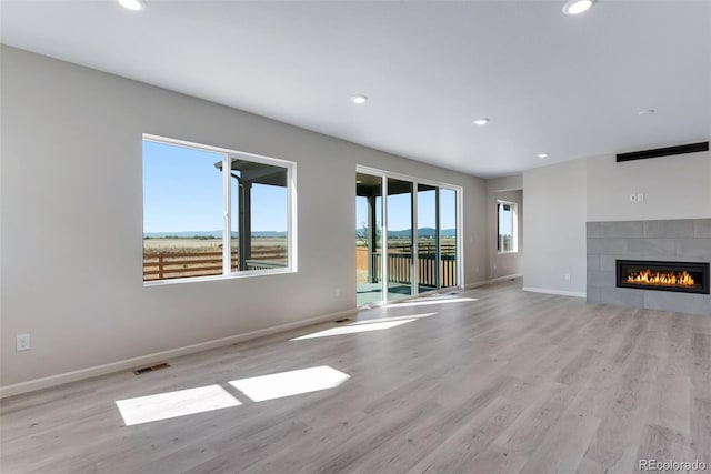 13398 E 99th Pl, Commerce City, CO 80022 - unfurnished living room with wood finished floors, recessed lighting, baseboards, and a tiled fireplace