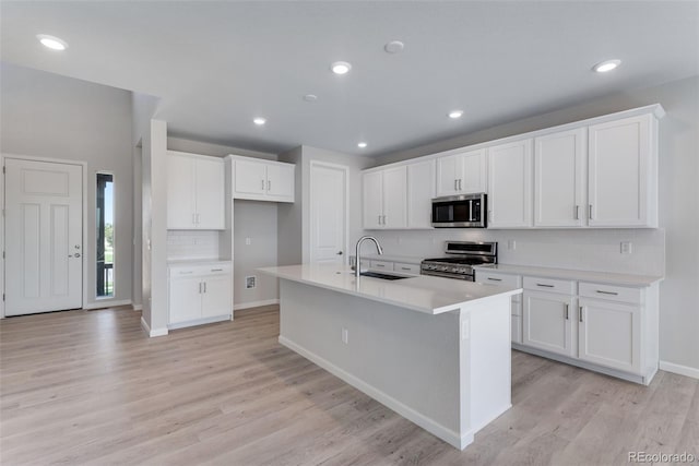 13398 E 99th Pl, Commerce City, CO 80022 - kitchen with stainless steel appliances, a sink, tasteful backsplash, light wood-style floors, and a center island with sink