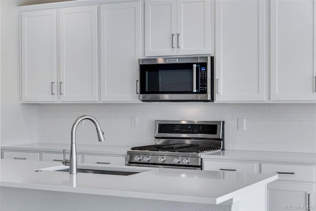 13398 E 99th Pl, Commerce City, CO 80022 - kitchen featuring stainless steel microwave, stove, a sink, and white cabinetry