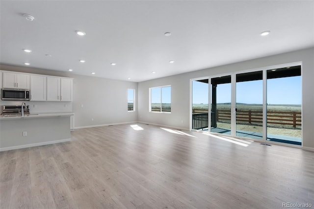 13398 E 99th Pl, Commerce City, CO 80022 - unfurnished living room with light wood-type flooring, recessed lighting, and baseboards