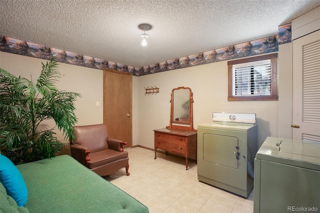 clothes washing area with separate washer and dryer and a textured ceiling