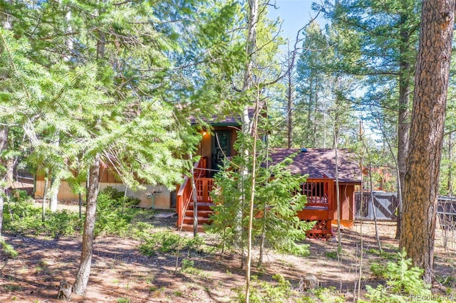 1321 W Midland Ave, Woodland Park, CO 80863 - rear view of house with fence, stairs, a deck, and roof with shingles