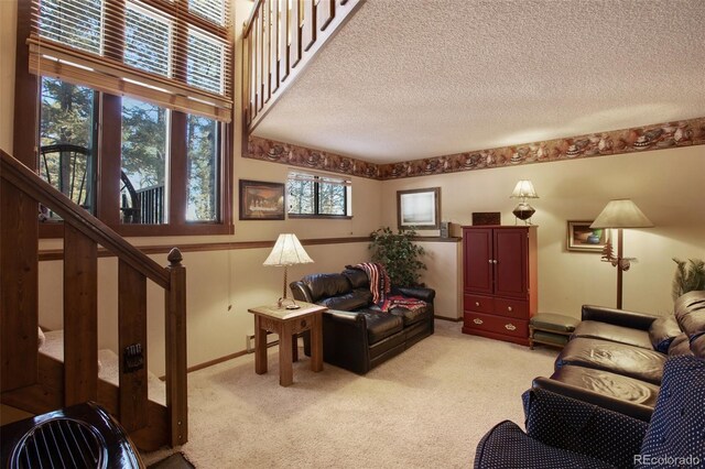 1321 W Midland Ave, Woodland Park, CO 80863 - living area featuring light colored carpet, stairway, a textured ceiling, and plenty of natural light