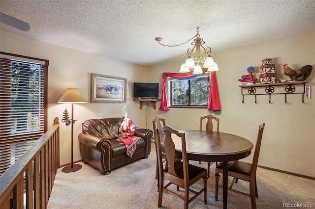 1321 W Midland Ave, Woodland Park, CO 80863 - dining area featuring light carpet, a chandelier, a textured ceiling, and baseboards