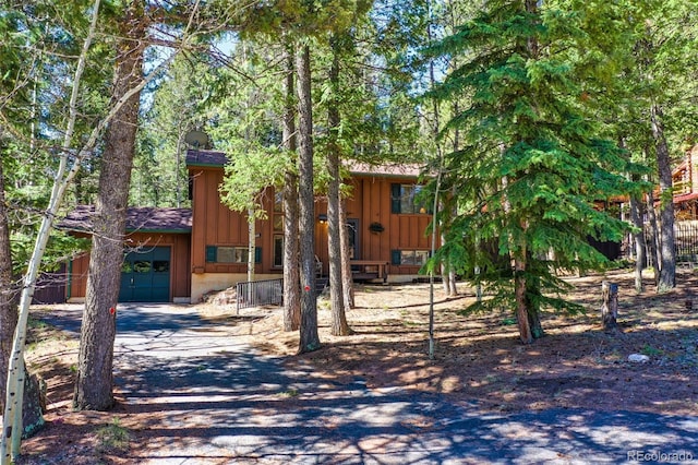 1321 W Midland Ave, Woodland Park, CO 80863 - rustic home with board and batten siding, fence, and driveway