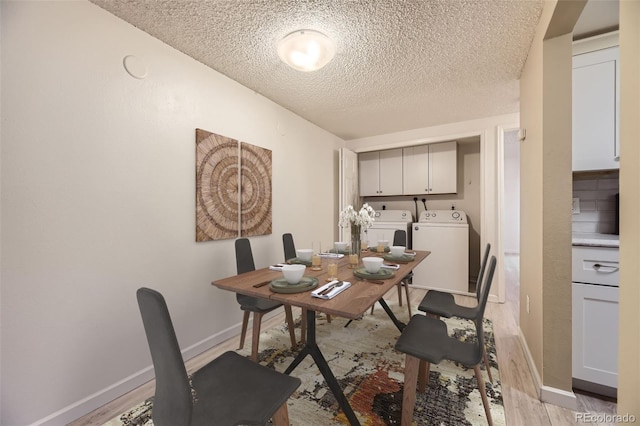 dining space with washing machine and clothes dryer, light hardwood / wood-style flooring, and a textured ceiling