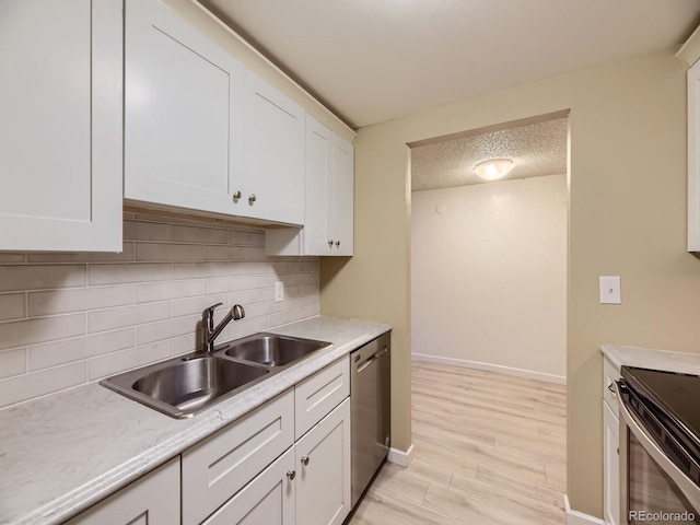 kitchen with white cabinetry, light wood-type flooring, a textured ceiling, and appliances with stainless steel finishes