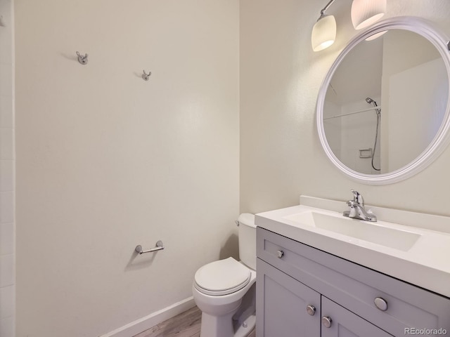 bathroom featuring walk in shower, toilet, vanity, and hardwood / wood-style flooring