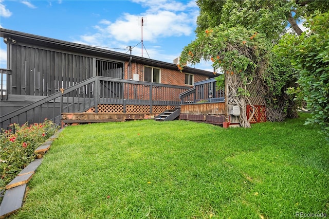 8079 W 67th Ave, Arvada, CO 80004 - rear view of house featuring a wooden deck, a yard, brick siding, and stairway