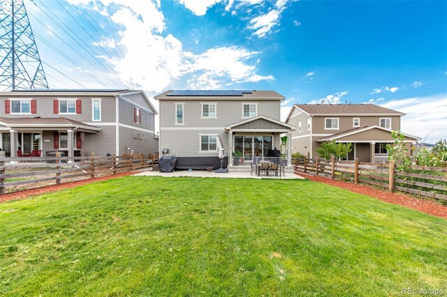 back of house featuring an outdoor hangout area, a patio area, a yard, and solar panels