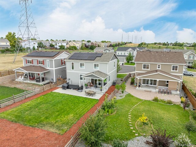 back of property with a gazebo, a yard, solar panels, and a patio