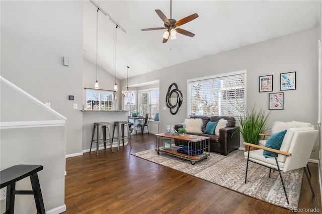 living room featuring baseboards, high vaulted ceiling, wood finished floors, and a ceiling fan