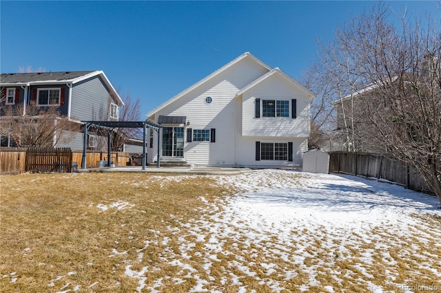 snow covered property featuring an outbuilding, a pergola, a fenced backyard, a shed, and a patio area