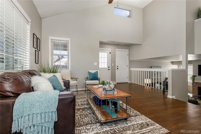 living area featuring baseboards, high vaulted ceiling, ceiling fan, and wood finished floors