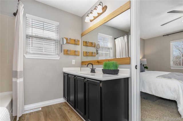 bathroom with vanity, a healthy amount of sunlight, visible vents, and baseboards