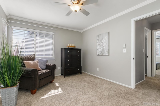 sitting room featuring a ceiling fan, baseboards, carpet, and crown molding