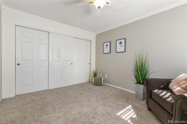 living area with baseboards, carpet floors, ornamental molding, and a ceiling fan