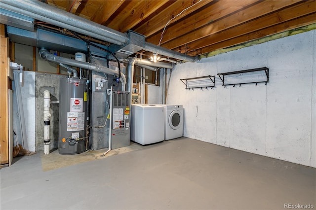 unfinished basement featuring washer and clothes dryer, heating unit, and gas water heater