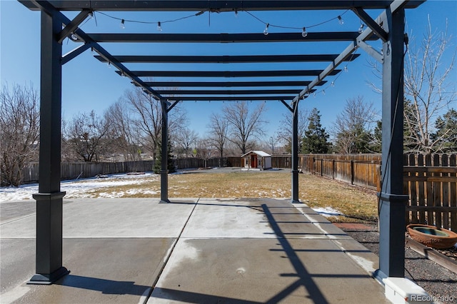 view of patio with an outbuilding, a pergola, and a fenced backyard