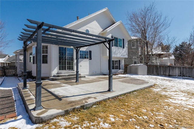 snow covered property featuring entry steps, a storage shed, fence, and a pergola