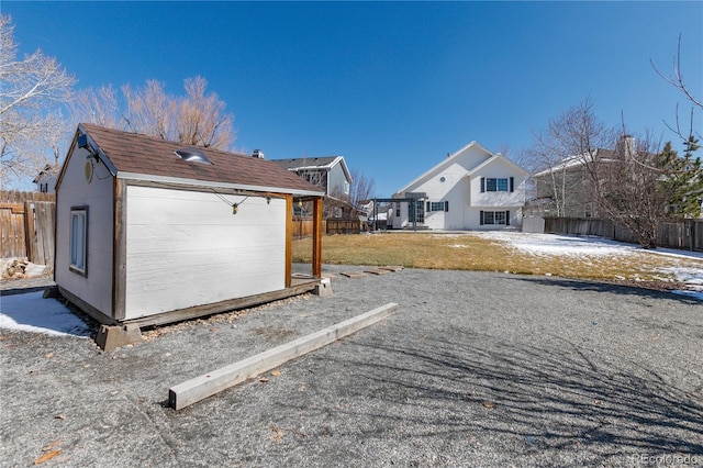 view of property exterior with a yard, an outdoor structure, a storage shed, and a fenced backyard