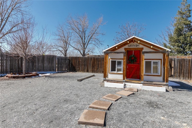 view of outdoor structure with entry steps, an outdoor structure, and a fenced backyard