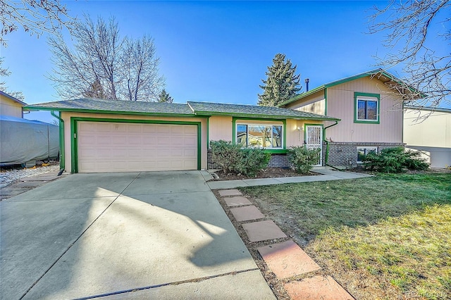 tri-level home with a garage and a front yard