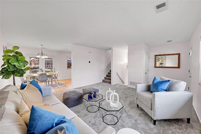 living room with light carpet and an inviting chandelier